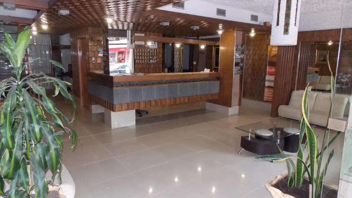 Recepción del Hotel Shelton, con plantas y paneles de madera